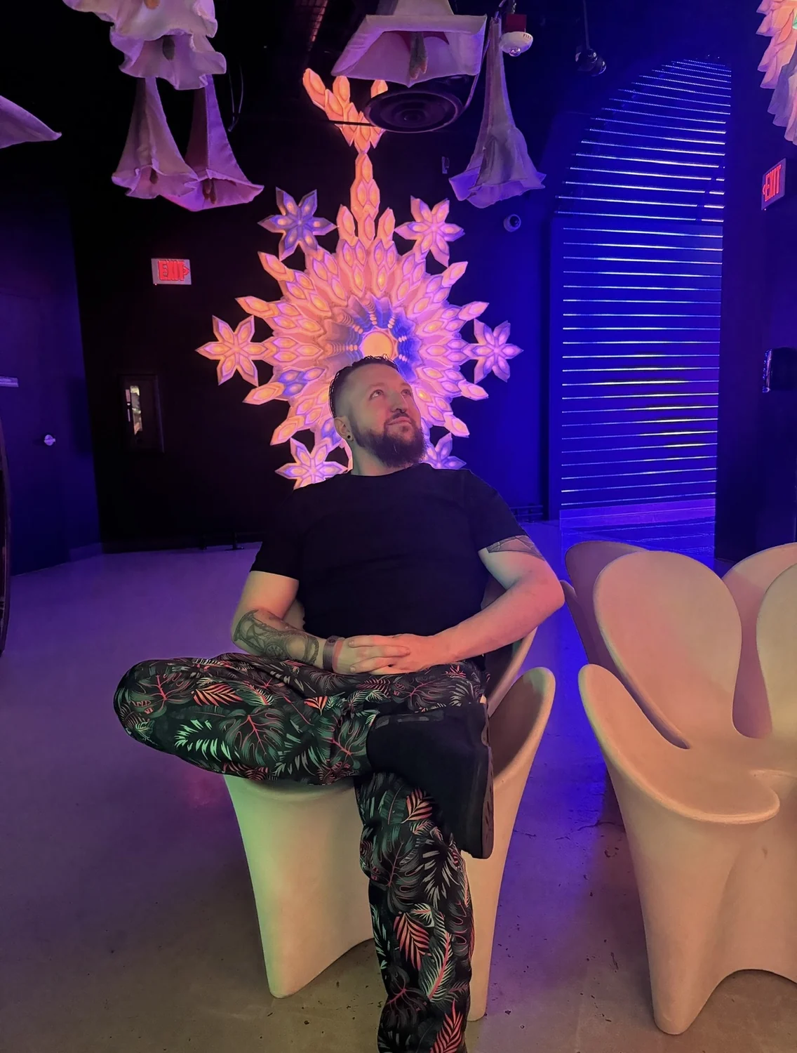 Kevin Holmes sitting in a colorful immersive space